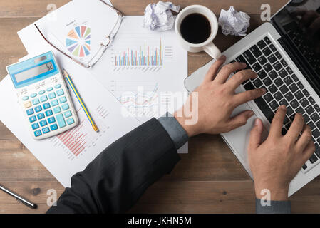 Business man using computer to developing a business project and analyzing market data information. Top view Stock Photo