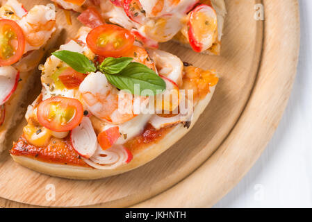 seafood Pizza on wood palte and white wood background Stock Photo