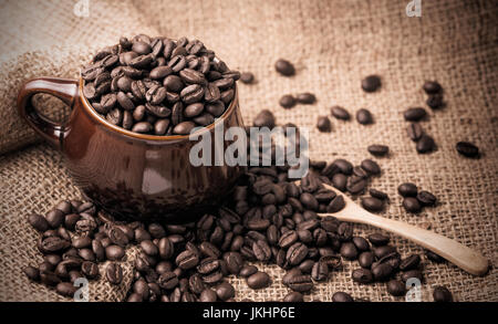 coffee beans in cup on sackcloth, vintage and dark tone Stock Photo