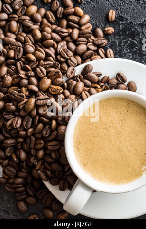 Hot coffee cappuccino and coffee beans on black table. Top view. Stock Photo