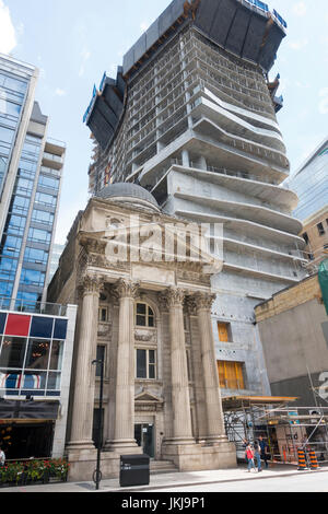 The historic Bank of Canada building on Yonge Street in downtown Toronto is dwarfed by the adjacent Massey Tower condos being constructed in 2017 Stock Photo
