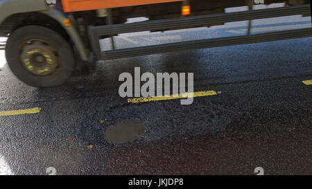 large pothole on road filled with water glasgow scotland uk Stock Photo