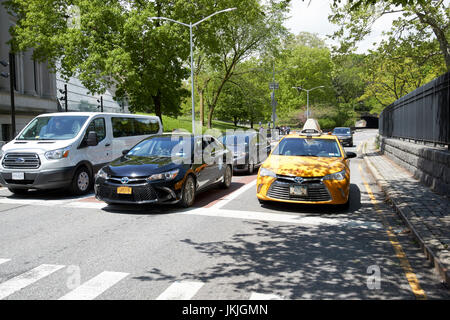 taxi and cars on transverse road through central park west 86th street New York City USA Stock Photo