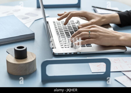 Girl using laptop in office Stock Photo