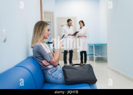 Female Patient Being Reassured By Doctors In Hospital Room Stock Photo