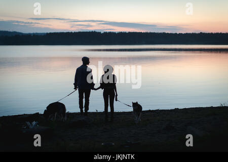 Couple with two dogs on beach Stock Photo