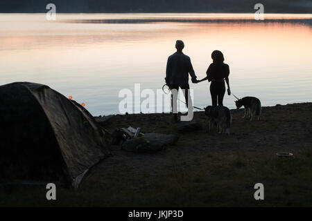 Couple with two dogs on beach Stock Photo