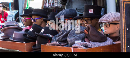 Street market stand selling hats, spectacles, sunglasses displayed on mannequin heads Stock Photo