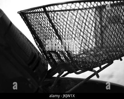 BLACK AND WHITE PHOTO OF BLURRY SHOT OF MOTORCYCLE FRONT METAL BASKET Stock Photo