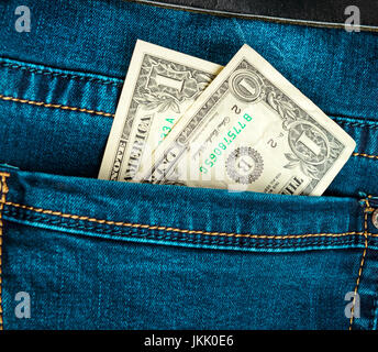 Blue trendy jeans with two american dollars bill on its pocket Stock Photo