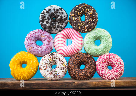 Colorful vibrant donuts pyramide against blue vibrant bacground Stock Photo