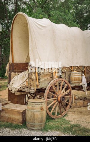 Restored old historic covered wagon or Conestoga wagon with wooden boxes and barrels part of a Civil War reenactment in Marbury Alabama USA. Stock Photo