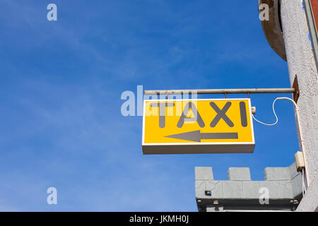 Yellow Taxi Sign against the blue sky Stock Photo