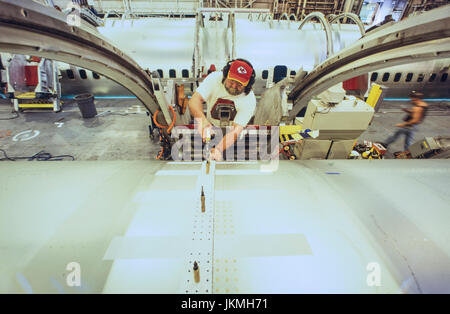 Skilled aerospace workers build a commercial Boeing 737 aircraft. Stock Photo