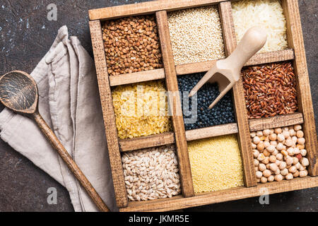 assortment of different cereals and seeds in a box on dark brown background, top view Stock Photo