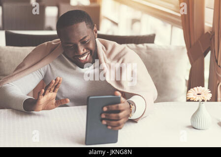 Delighted positive man making a video call Stock Photo