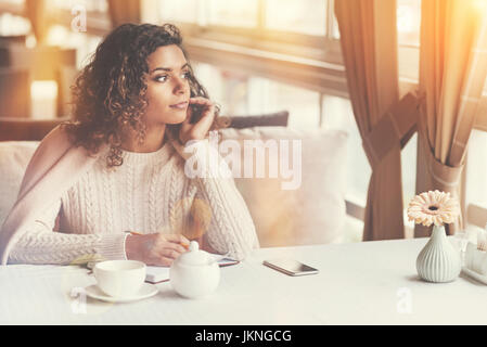 Attractive dreamy woman looking in the window Stock Photo