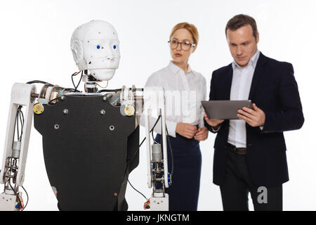 Productive serious scientists studying robots abilities Stock Photo