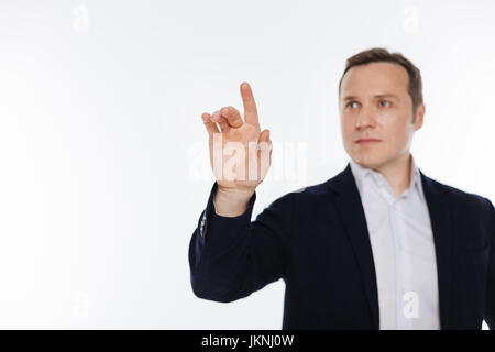 Radiant clever gentleman pretending touching something Stock Photo