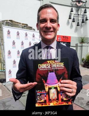 Los Angeles, USA. 24th July, 2017. Mayor of Los Angeles Eric Garcetti shows the first commemorative, full-color souvenir book to mark the 90-year history of the TCL Chinese Theatre in Los Angeles, the United States, July 24, 2017. Credit: Zhao Hanrong/Xinhua/Alamy Live News Stock Photo