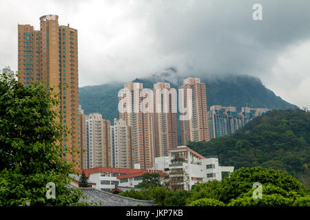 China. A cloudy day in Hong Kong. Residential skyscrapers against the backdrop of wooded mountains and low clouds Stock Photo