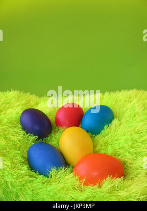 Six easter eggs lie on shaggy green carpet. Stock Photo