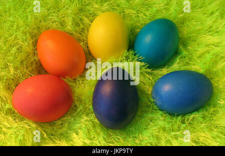 Six easter eggs lie on shaggy yellow-green carpet. Stock Photo