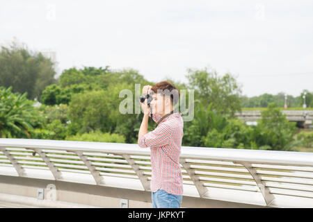 Young asian man taking a photo in city Stock Photo