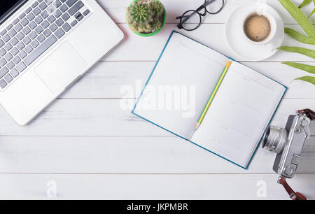 blank calendar with computer, coffee and vintage camera on white wood background, business concept Stock Photo