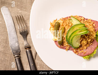 Danish specialties and national dishes, high-quality open sandwich. Salami with crispy onion, remoulade and cucumber served on a plate ready for eatin Stock Photo