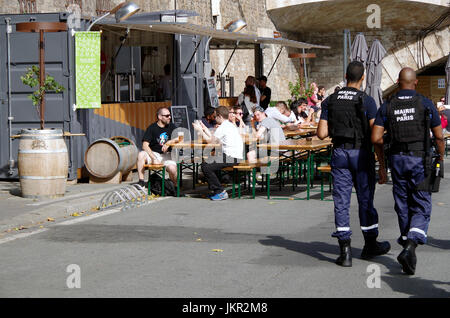 Temporary bar, part of Paris Plages, in converted shipping container, trestle tables and benches, people drinking and chatting, Stock Photo