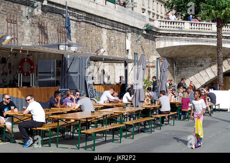 Temporary bar, part of Paris Plages, in converted shipping container, trestle tables and benches, people drinking and chatting, Stock Photo