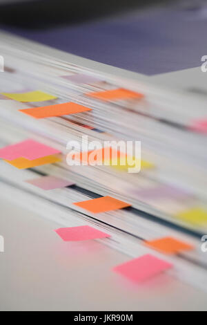 High angle view of stack of books with colorful bookmarks on table Stock Photo