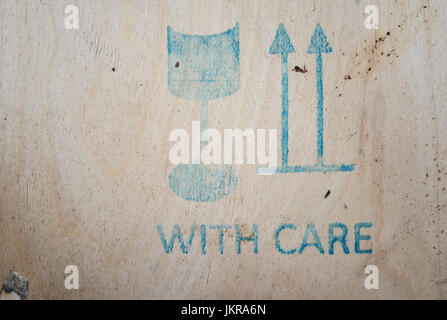 Close-up of WITH CARE sign on wooden crate Stock Photo