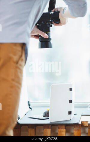 Cropped image of photographer photographing food on table against window Stock Photo