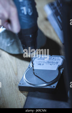 Cropped image of hand drilling on hard drive at table Stock Photo