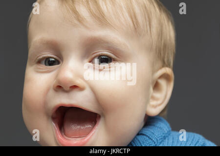 Close-up portrait of happy toddler against gray background Stock Photo