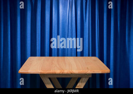wooden table with blue curtain background Stock Photo