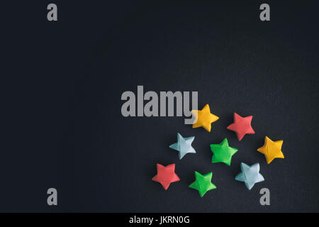 Colorful origami lucky stars on a black background. Stock Photo