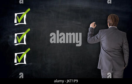 Businessman writing with checkbox concept on blackboard. Stock Photo