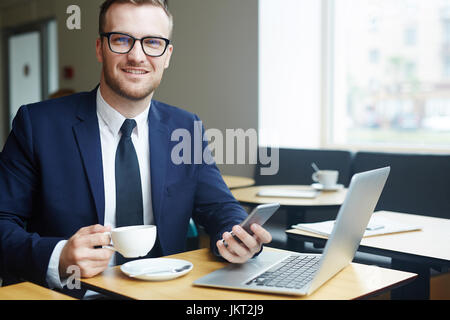 Smart manager having coffee break in cafe Stock Photo