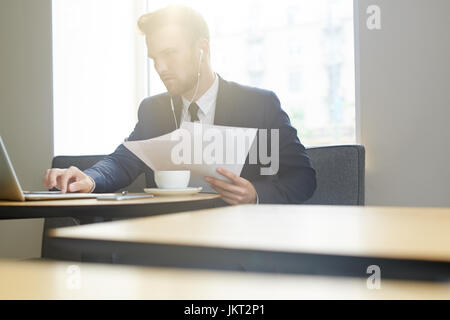 Mobile businessman concentrating on network in cafe Stock Photo
