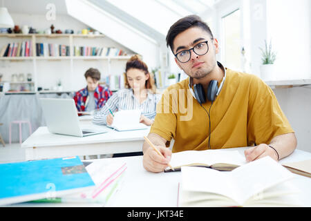 Diligent learner making notes in copybook at seminar Stock Photo