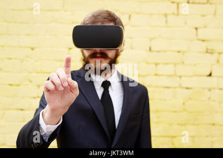 Hand of businessman in headset touching imaginary button or display Stock Photo
