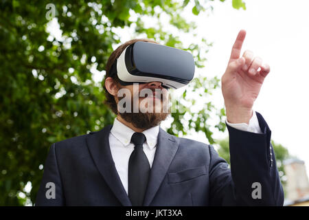 Business professional with vr headset pressing virtual button Stock Photo