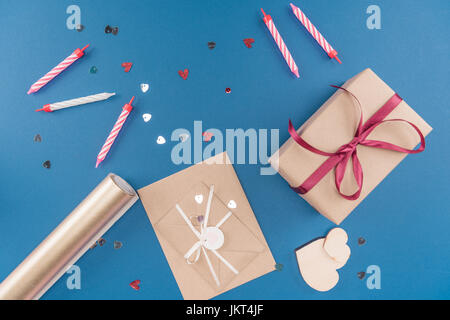 top view of gift box, candles and envelope isolated on blue, birthday party concept Stock Photo