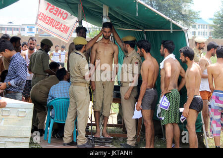 Anantnag, India. 24th July, 2017. A policeman measures the height of a Kashmiri youth during a police recruitment rally on July 24, 2017 in Anantnag, India. A recruitment drive by the police in Kashmir evoked an overwhelming response, with nearly 3,000 young men and women turning up for it. The candidates, who have qualified the physical test, will have to appear in the written test for final selection for which the dates will be issued separately. Credit: Muneeb Ul Islam/Pacific Press/Alamy Live News Stock Photo