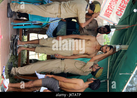 Anantnag, India. 24th July, 2017. A policeman measures the height of a Kashmiri youth during a police recruitment rally on July 24, 2017 in Anantnag, India. A recruitment drive by the police in Kashmir evoked an overwhelming response, with nearly 3,000 young men and women turning up for it. The candidates, who have qualified the physical test, will have to appear in the written test for final selection for which the dates will be issued separately. Credit: Muneeb Ul Islam/Pacific Press/Alamy Live News Stock Photo