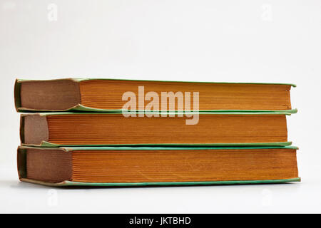 Three old books stacked on white background Stock Photo