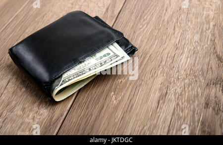 Old used men's purse with money on wood background Stock Photo